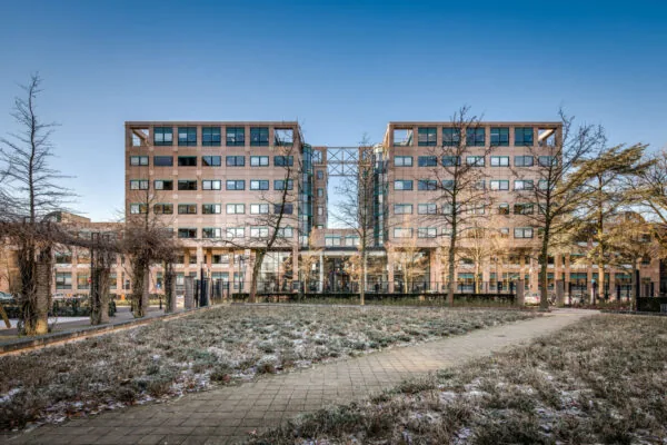 Kantoorgebouw aan de Arthur van Schendelstraat met een besneeuwd plantsoen en wandelpad op de voorgrond.